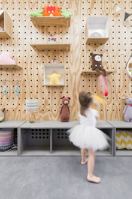 a playroom styled with large pegboards with shelves and hooks and are used to organize the space and make storage effective