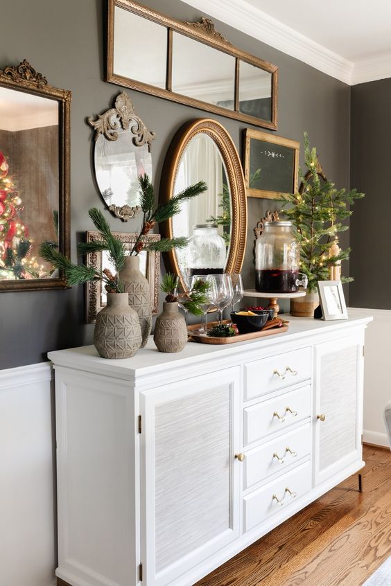 a white console table, a grey wall, a gallery wall of mirrors in chic vintage frames are a cool and catchy combo