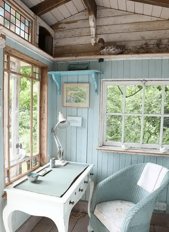 an aqua and turquoise colored home office in a shed looks cozy and cute and it inspires to work and dream