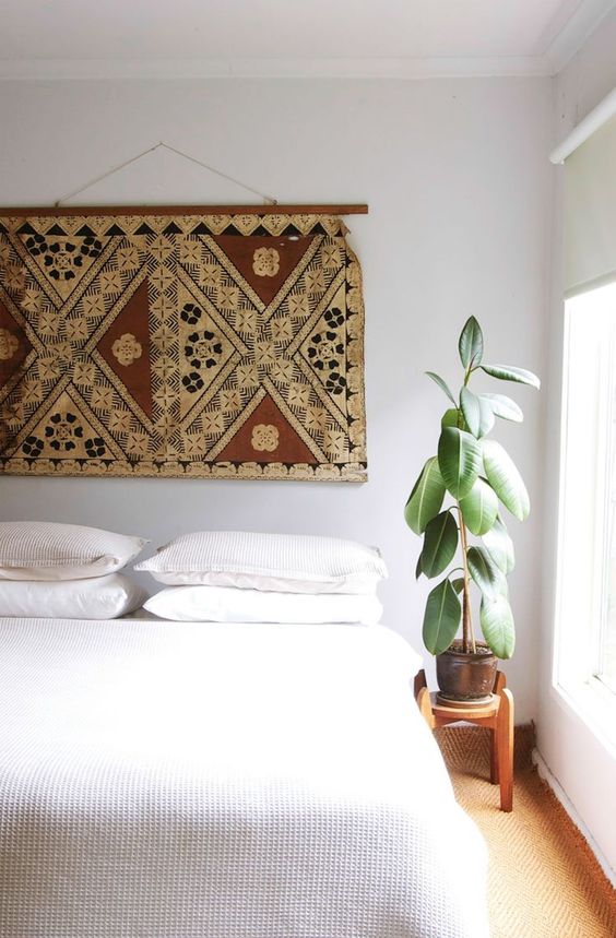 an elegant neutral bedroom with a printed boho rug over it to give your space a free-spirited feel