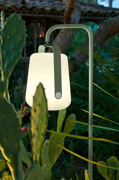 an outdoor lamp with a green stand resembles of a flower but styled in a modern way