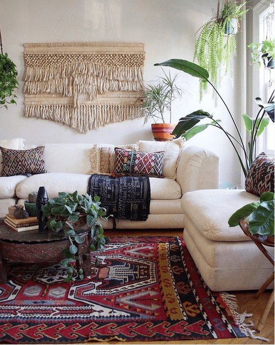 Colorful printed pillows, a printed rug and a large macrame hanging make the space boho like