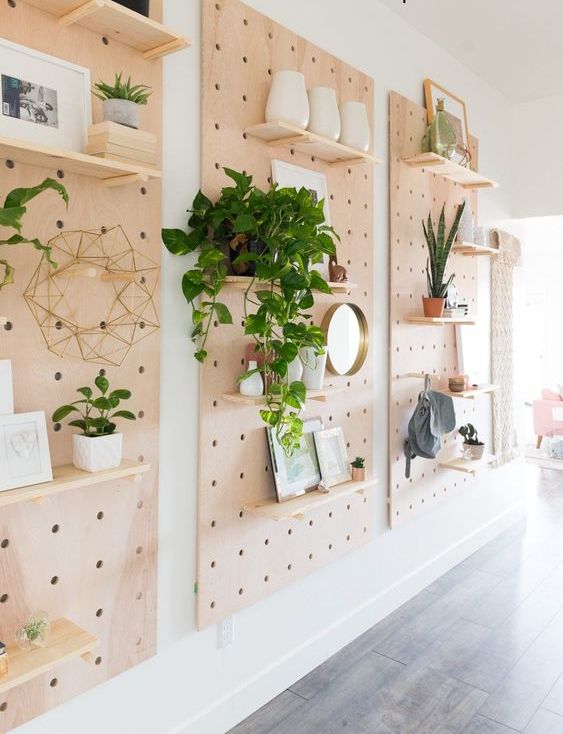 three pegboards on the wall, with shelves, potted plants, various decor and artwork are great for styling a modern space and get some display space