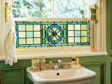 Side View Of A Sink Under A Stained Glass Window In A Green Bathroom