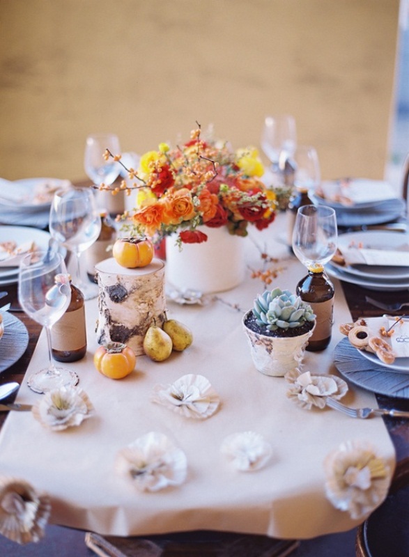 An elegant fall tablescape with neutral linens, bright blooms, fruits and veggies and a potted succulent plus porcelain
