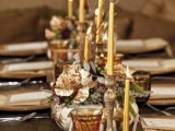 a chic fall tablescape with metallic chargers, candles, candleholders and faux pumpkins, leaves, greenery and other stuff