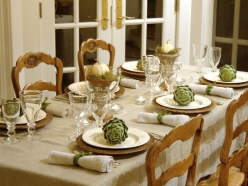 a vintage farmhouse fall tablescape with metallic chargers, neutral linens, artichokes, a white pumpkin and moss