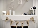 an elegant black and white Halloween mantel with black and white pumpkins, a burlap banner and a faux blackbird for a chic look