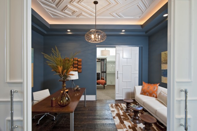 geometric molding on the ceiling and a matching sliding door add chic and style to the space