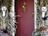 classic Halloween front porch decorating with Jack-o-lanterns, corn husks, ghosts, fall leaves and pumpkins is chic