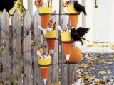 a candy corn stand with sweets for kids and faux blackbirds is great to treat your neighbors’ kids