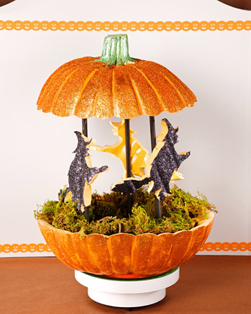 a glitter orange pumpkin with moss and paper witches is a cool decoration for the fall and Halloween