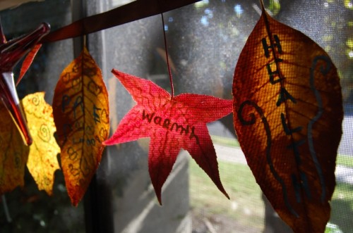 a garland of fabric and just dried leaves with wishes is a great all-natural decoration for Thanksgiving, both indoors and outdoors