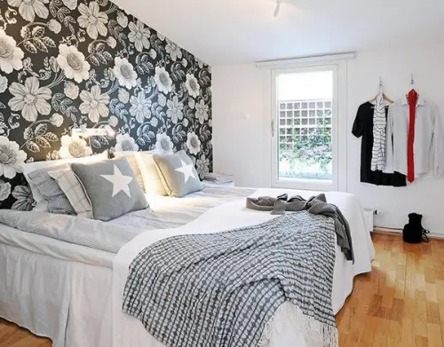 a white bedroom spruced up with a dark floral accent wall makes it more interesting and bold