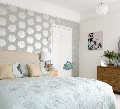 a pastel bedroom with a light green printed wall for a slight touch of color and pattern