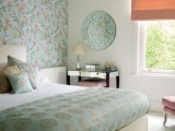 a grene floral accent wall, matching bedding and a printed plate on the wall for subtle and soft touches