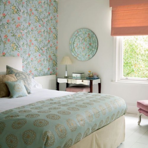 a grene floral accent wall, matching bedding and a printed plate on the wall for subtle and soft touches