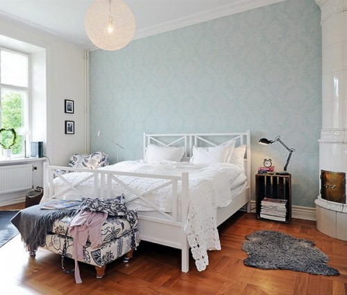 a neutral bedroom with a pastel blue printed wall that gives a light touch of color and makes the room interesting