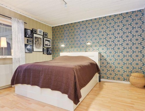 a neutral bedroom with a retro wallpaper accent wall that adds catchiness and brings style to the space