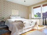 a neutral bedroom with a printed accent wall that subtly adds interest and chic to the room without being too much