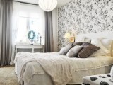 a monochromatic room with a botanical print headboard wall that adds pattern to the space