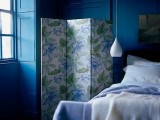 a white pendant bedside lamp contrasts the navy bedroom and matches the bed bringing light