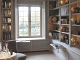 a window seat with no upholstery and bookshelves built all around and next to each seat for a stylish reading nook