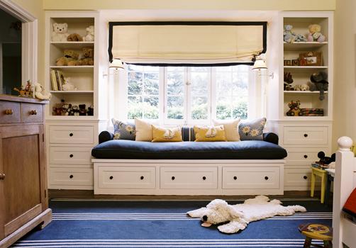 a cozy windowsill space with a large and soft daybed with drawers and built in shelves on each side is ideal for a kid's room