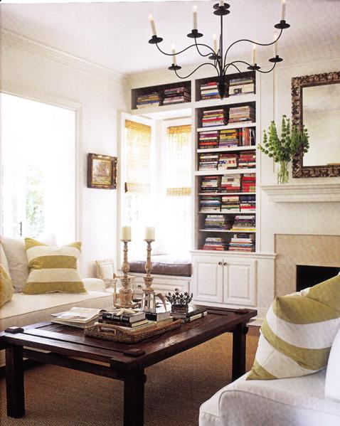 a small and cozy reading nook with lots of bookshelves built-in and a small sitting space next to it