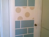 a white door stenciled with tile-like patterns and polka dots to make it whimsy and bright
