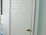a turquoise door with white patterns on it that add eye-catchiness and make it stand out in the wall