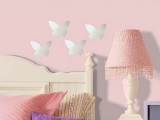 silver butterfly decals on a light pink wall make the space veyr cute and very girlish
