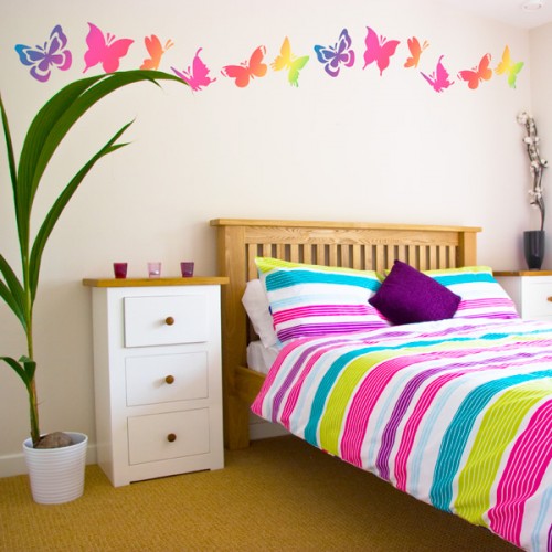 colorful butterfly wall decals and matching bright striped bedding for a bold and fun bedroom look