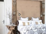 a coffee table made of driftwood and some branches in a clear vase will make your bedroom feel super natural and coastal