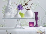 a glass stand with an arrangement of vases and lots of natural branches can work as a spring centerpiece