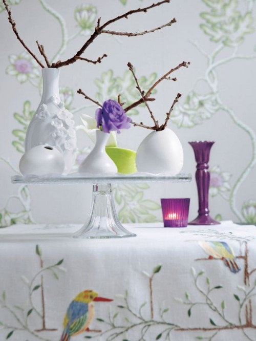 a glass stand with an arrangement of vases and lots of natural branches can work as a spring centerpiece