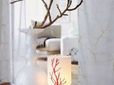 a white vase with spectacular tree branches covered with moss is a cool arrangement with a slight woodland feel