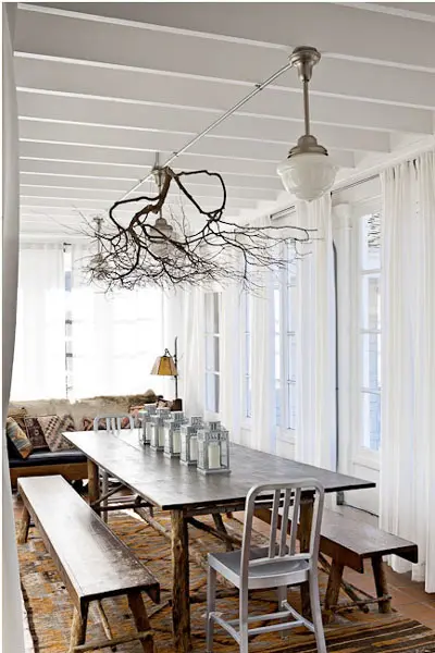 attach tree branches to the ceiling railing, which holds your lamps, to make the space feel more natural