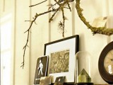 moss covered branches attached to the wall and yarn blooms will make your mantel more eye-catching