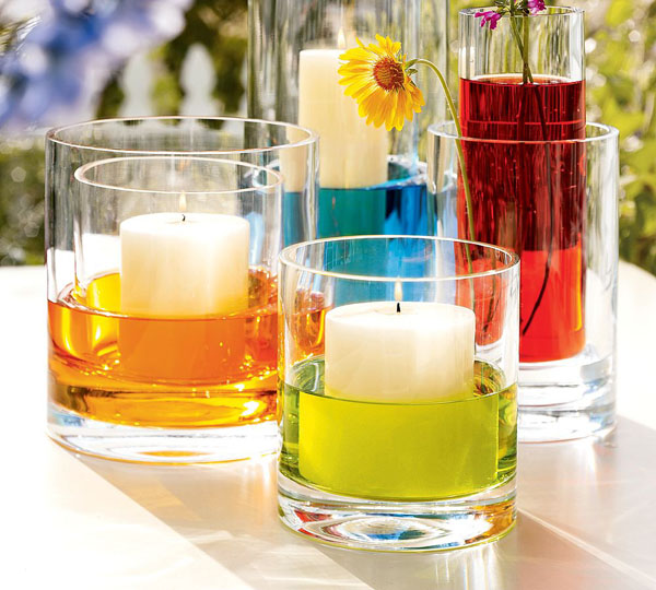 glasses with colorful water and pillar candles placed into them in other glasses look fun and bold