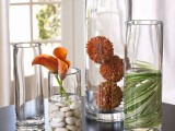 large and tall glass vases with pebbles, leaves and dried blooms create a cool chic fall arrangement