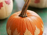 a pumpkin with dried fall leaves attached to it is a nice and bold decoration for the fall