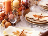 fall leaves attached to napkins to accessorize them and a pumpkin and candle centerpiece for a natural fall tablescape