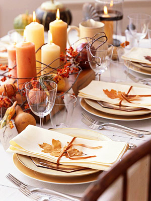 fall leaves attached to napkins to accessorize them and a pumpkin and candle centerpiece for a natural fall tablescape