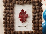 a fall decoration of white burlap, dried acorns and a fall leaf in burgundy is a very chic and natural decoration