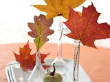 test tubes with colorful fall leaves compose a cool fall decoration for cheap and brings color to the space