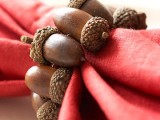 a red napkin with an acorn napkin ring is a bold accessory for your fall tablescape