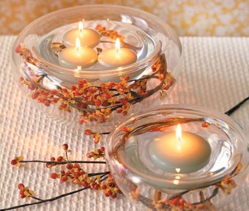 glass bowls wrapped with vine and berries and with floating candles will bring a cozy feel to your reception