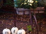 a cart with cabbages and white blooms and white pumpkins for decorating a wedding reception or ceremony space
