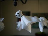 funny napkin ghosts hanging on a chandelier can be an easy craft for Halloween that even your kids can make